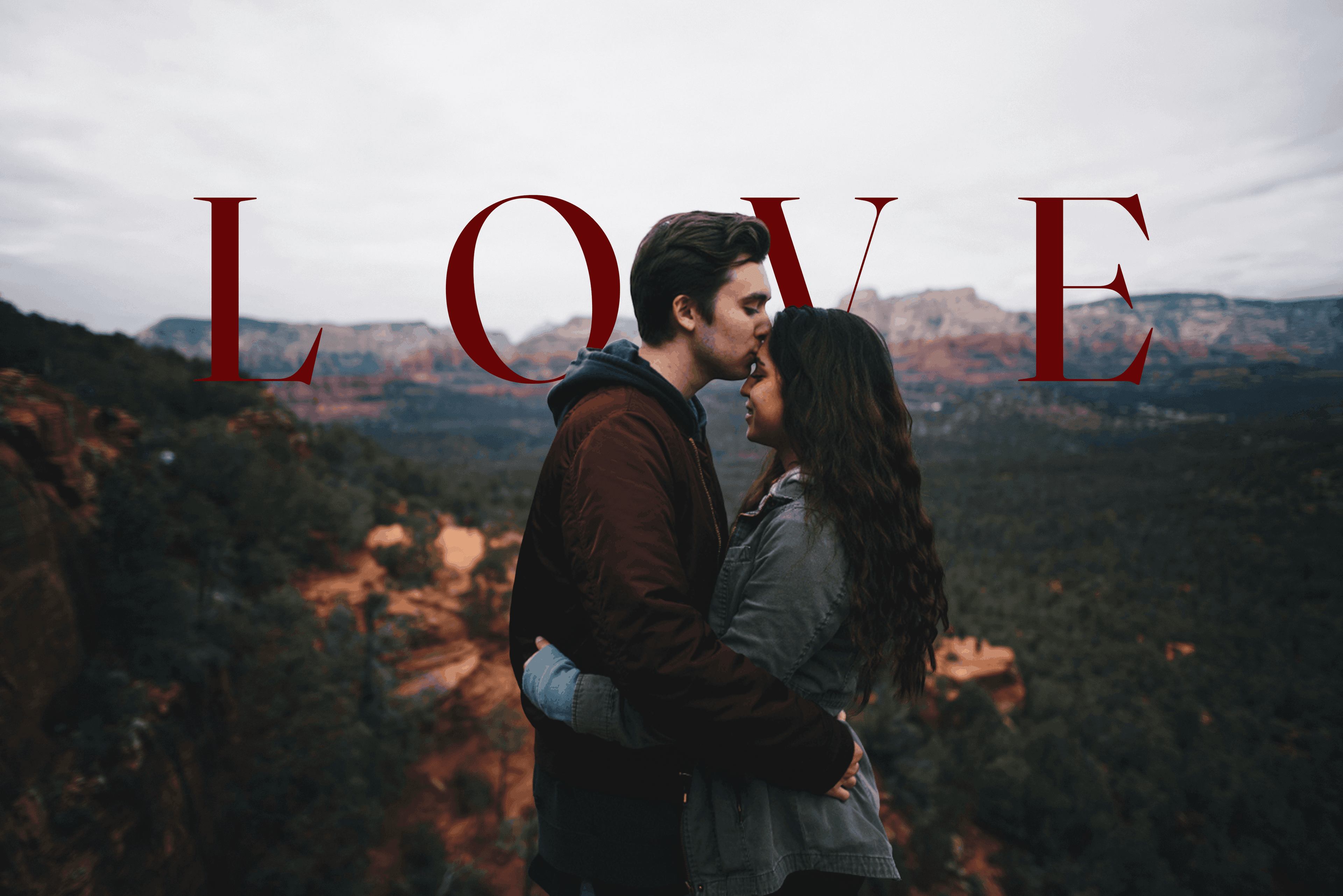 Text behind image effect — LOVE text placed behind a couple at a scenic overlook